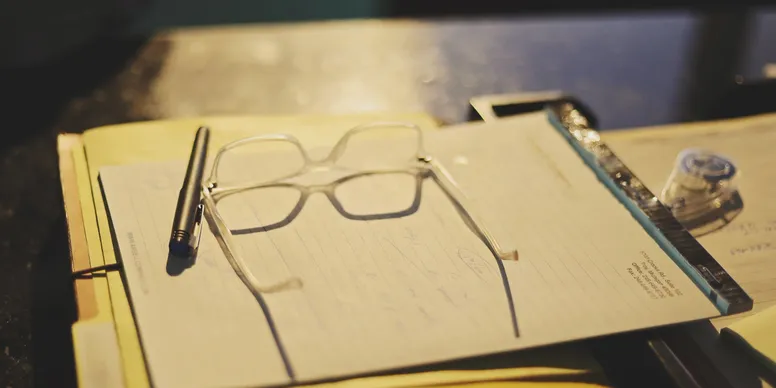 Lawyer's desk with note pad and glasses